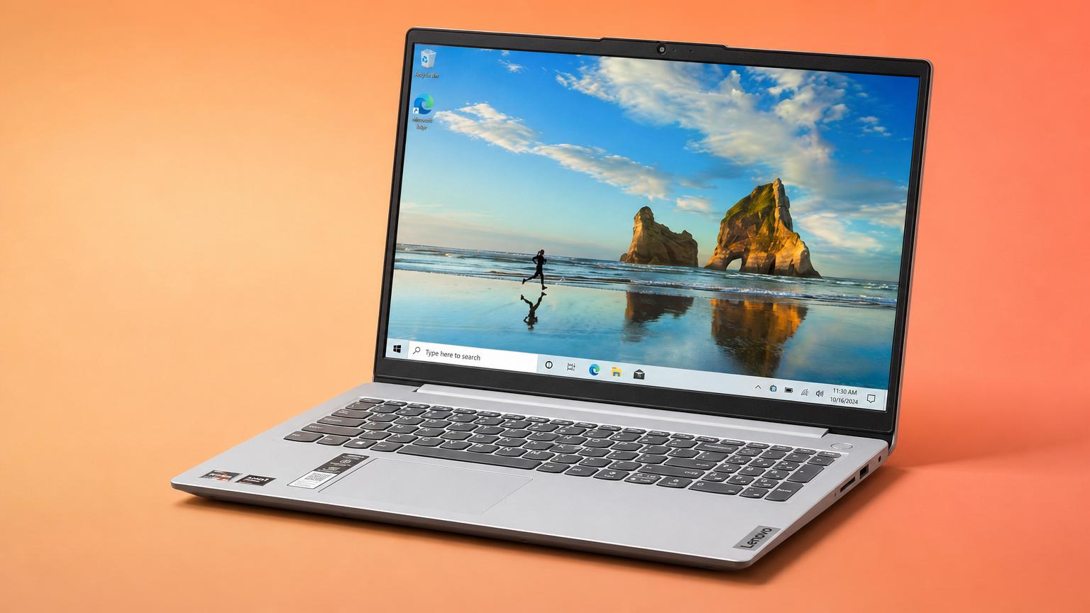 Notebook prateado aberto sobre mesa de madeira em coworking com luz natural